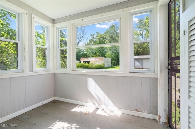 19501 Libby Rd, Maple Heights, OH 44137 - unfurnished sunroom with healthy amount of natural light, wooden walls, and wood finished floors