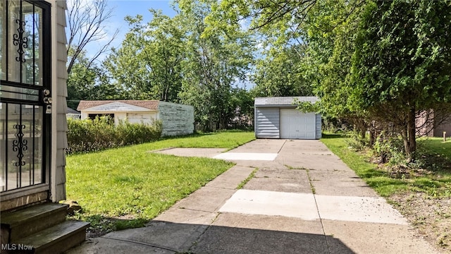 19501 Libby Rd, Maple Heights, OH 44137 - view of grassy yard with concrete driveway, an outdoor structure, entry steps, and a garage
