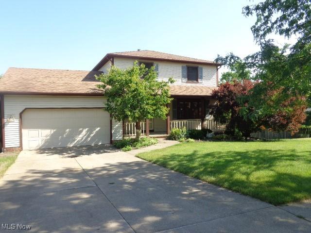 4326 Wood Thrush Dr, Parma, OH 44134 - view of front of property with driveway, a front yard, an attached garage, and covered porch