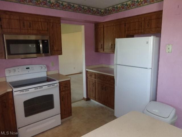 4326 Wood Thrush Dr, Parma, OH 44134 - kitchen with white appliances, brown cabinets, light countertops, and light flooring