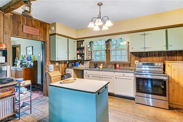 337 Youngstown Kingsville Rd SE, Vienna, OH 44473 - kitchen with electric stove, light wood-style floors, a chandelier, white cabinetry, and wooden walls