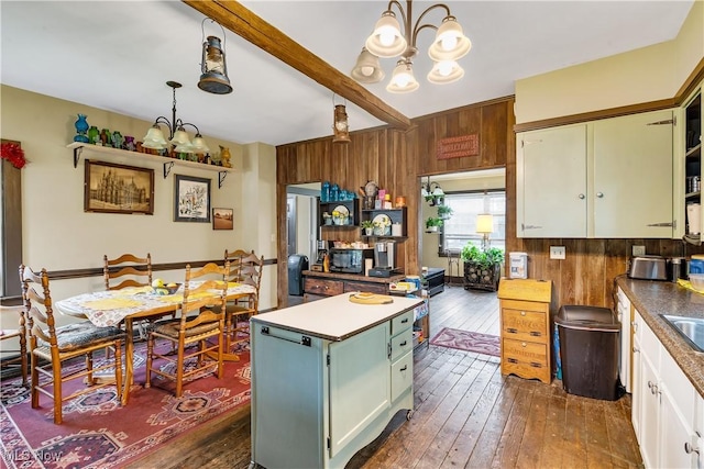 337 Youngstown Kingsville Rd SE, Vienna, OH 44473 - kitchen with a chandelier, dark wood-type flooring, white cabinetry, wooden walls, and a kitchen island