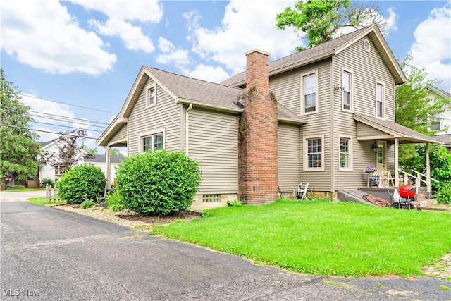 337 Youngstown Kingsville Rd SE, Vienna, OH 44473 - view of home's exterior with a chimney, a yard, and roof with shingles