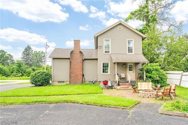 337 Youngstown Kingsville Rd SE, Vienna, OH 44473 - back of house with an outdoor fire pit, roof with shingles, and a chimney