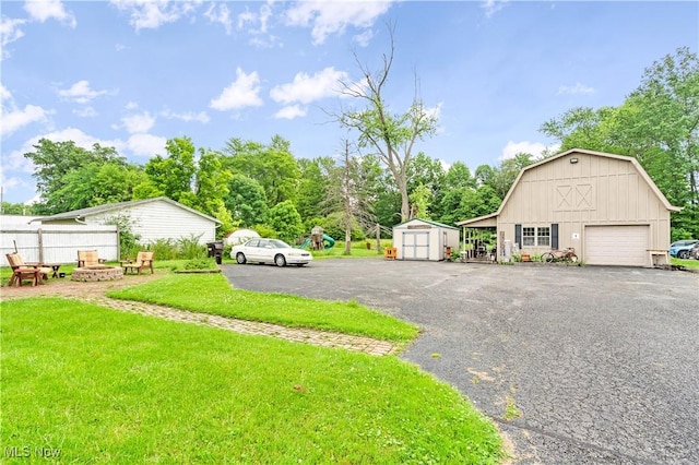 337 Youngstown Kingsville Rd SE, Vienna, OH 44473 - view of green lawn with an outdoor fire pit, driveway, a shed, a garage, and a barn