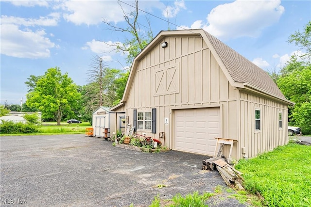 337 Youngstown Kingsville Rd SE, Vienna, OH 44473 - view of home's exterior with board and batten siding, a shingled roof, an outdoor structure, a barn, and a gambrel roof
