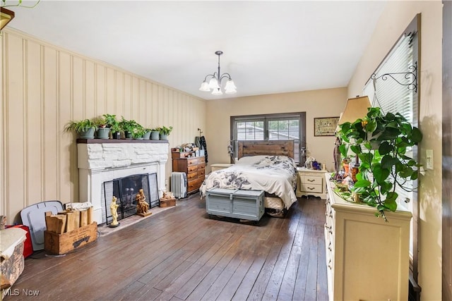 337 Youngstown Kingsville Rd SE, Vienna, OH 44473 - bedroom with dark wood-type flooring, a chandelier, and a stone fireplace
