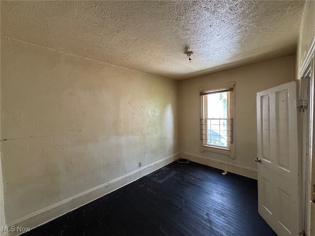 1185 E 74th St, Cleveland, OH 44103 - spare room with a textured ceiling and dark wood-style flooring