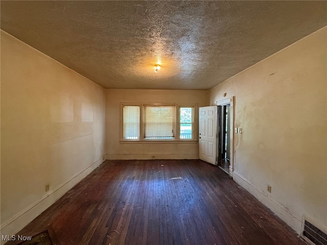 1185 E 74th St, Cleveland, OH 44103 - unfurnished room featuring dark wood-style flooring and a textured ceiling