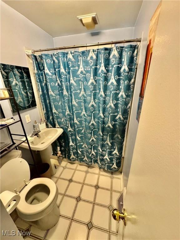 6033 E 135th St, Garfield Heights, OH 44125 - bathroom with tile patterned floors and a shower with shower curtain