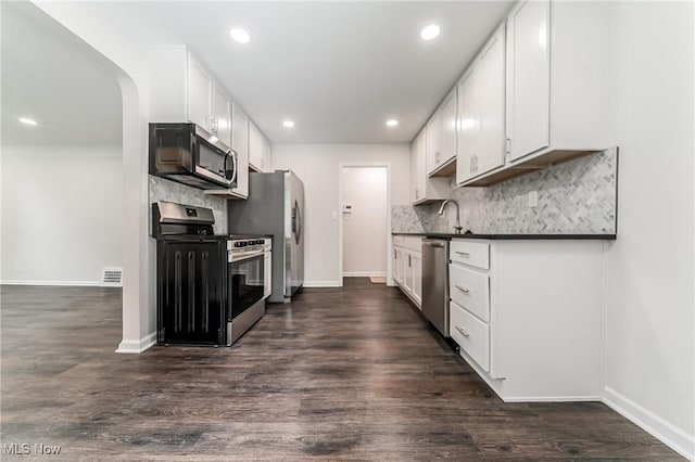 17207 Maple Heights Blvd, Maple Heights, OH 44137 - kitchen featuring appliances with stainless steel finishes, dark countertops, backsplash, white cabinets, and recessed lighting