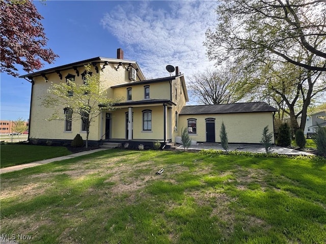 203 W 6th St, Dover, OH 44622 - rear view of house with a lawn, stucco siding, a chimney, and a porch