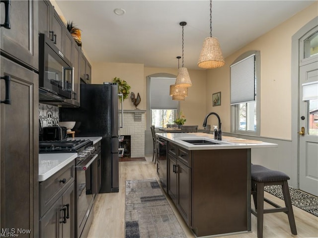 203 W 6th St, Dover, OH 44622 - kitchen featuring high quality appliances, plenty of natural light, an island with sink, and light wood-type flooring