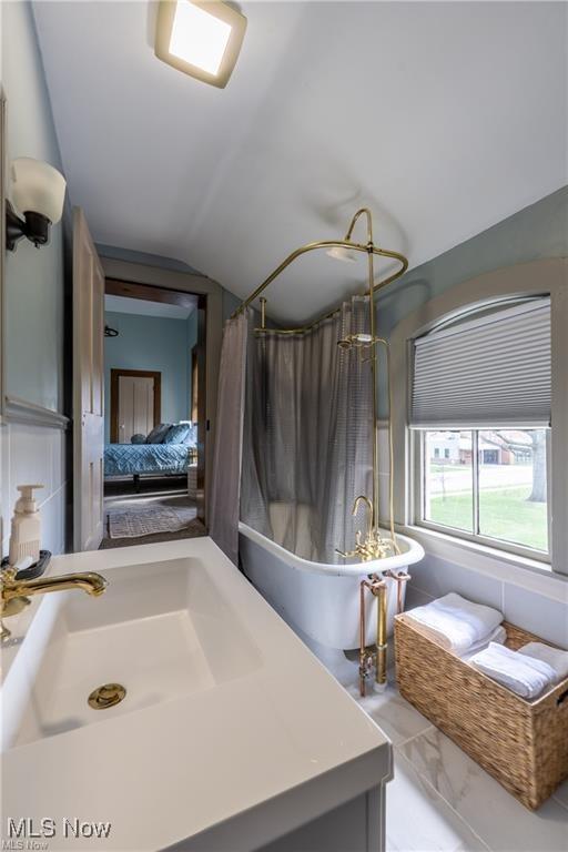 203 W 6th St, Dover, OH 44622 - bathroom featuring marble finish floors, vanity, lofted ceiling, and ensuite bath