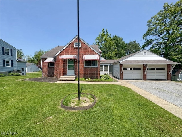15920 Grove St, Middlefield, OH 44062 - view of front of house featuring gravel driveway, brick siding, a front lawn, and a garage