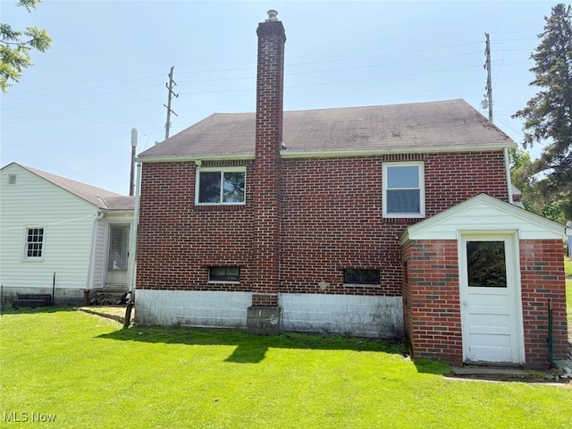 15920 Grove St, Middlefield, OH 44062 - back of house with brick siding, a chimney, a lawn, and roof with shingles