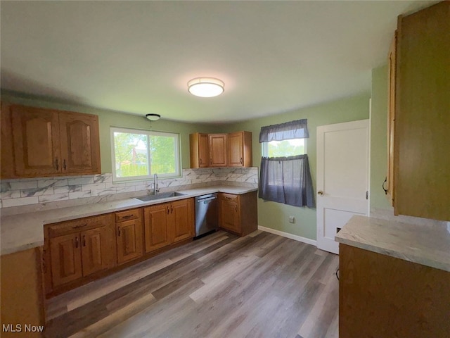 15920 Grove St, Middlefield, OH 44062 - kitchen featuring stainless steel dishwasher, brown cabinetry, tasteful backsplash, light countertops, and light wood-type flooring