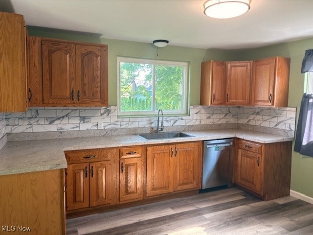 15920 Grove St, Middlefield, OH 44062 - kitchen with dishwasher, brown cabinetry, backsplash, light wood finished floors, and light countertops