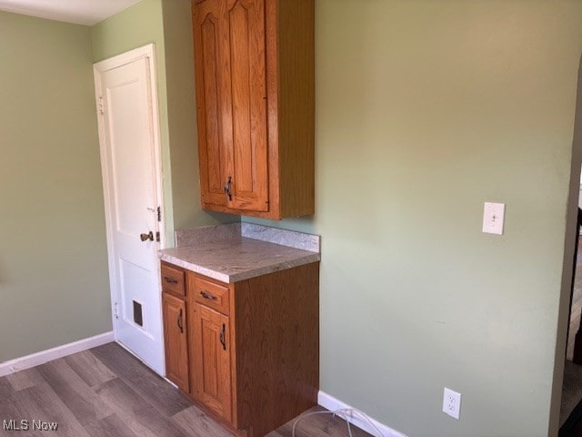 15920 Grove St, Middlefield, OH 44062 - kitchen with brown cabinetry, dark wood-type flooring, and light countertops