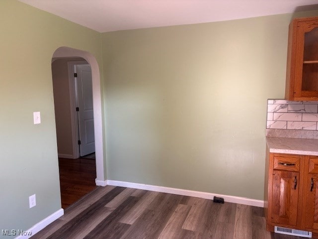 15920 Grove St, Middlefield, OH 44062 - unfurnished dining area with arched walkways and dark wood-style flooring