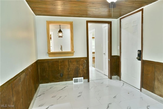 400 Spring St, Struthers, OH 44471 - spare room featuring wood ceiling, light marble finish flooring, a wainscoted wall, and wooden walls
