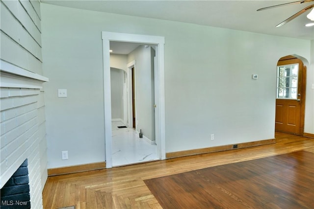 400 Spring St, Struthers, OH 44471 - empty room with arched walkways, a fireplace, and a ceiling fan