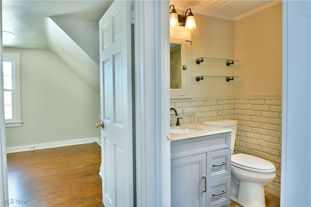 400 Spring St, Struthers, OH 44471 - bathroom featuring vanity, wood finished floors, lofted ceiling, brick wall, and crown molding