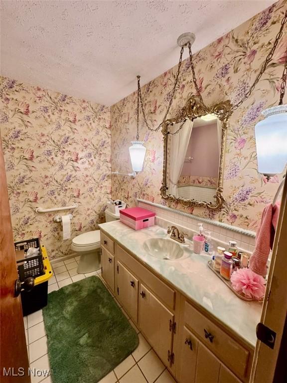 7621 Sandpiper Ave NW, North Canton, OH 44720 - bathroom with tile patterned floors, a textured ceiling, and vanity