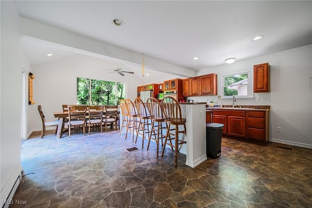 5251 Sugar Grove Rd, Cambridge, OH 43725 - kitchen featuring stone floors, lofted ceiling, a kitchen breakfast bar, stainless steel oven, and freestanding refrigerator