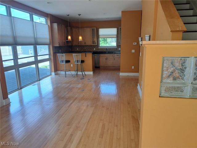 12595 Larchmere Blvd Unit E6, Cleveland, OH 44120 - kitchen with a kitchen bar, stainless steel dishwasher, light wood-type flooring, dark countertops, and tasteful backsplash