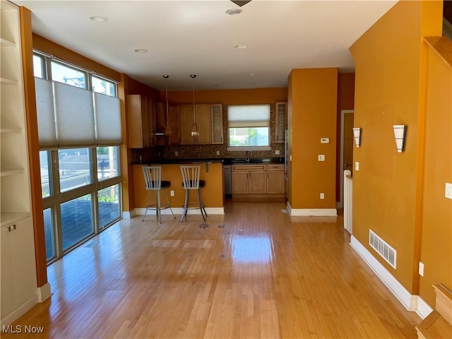 12595 Larchmere Blvd Unit E6, Cleveland, OH 44120 - kitchen featuring light wood finished floors, a breakfast bar area, dark countertops, tasteful backsplash, and appliances with stainless steel finishes