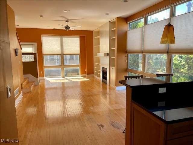 12595 Larchmere Blvd Unit E6, Cleveland, OH 44120 - unfurnished living room with a ceiling fan, a fireplace, light wood-style floors, stairway, and built in shelves