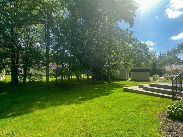 132 Beechwood Dr, Cortland, OH 44410 - view of grassy yard featuring a storage unit