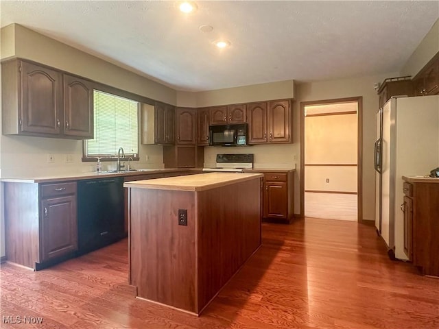 132 Beechwood Dr, Cortland, OH 44410 - kitchen featuring black appliances, dark wood-style floors, light countertops, a center island, and recessed lighting