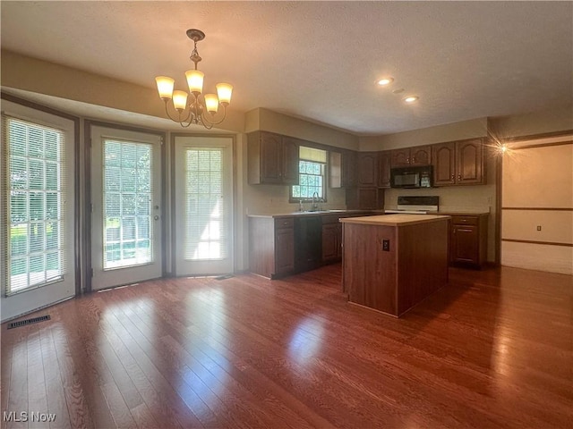 132 Beechwood Dr, Cortland, OH 44410 - kitchen featuring black microwave, range, a chandelier, light countertops, and dark wood-style flooring