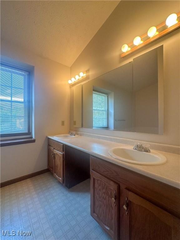 132 Beechwood Dr, Cortland, OH 44410 - full bathroom with lofted ceiling, double vanity, tile patterned floors, and a textured ceiling