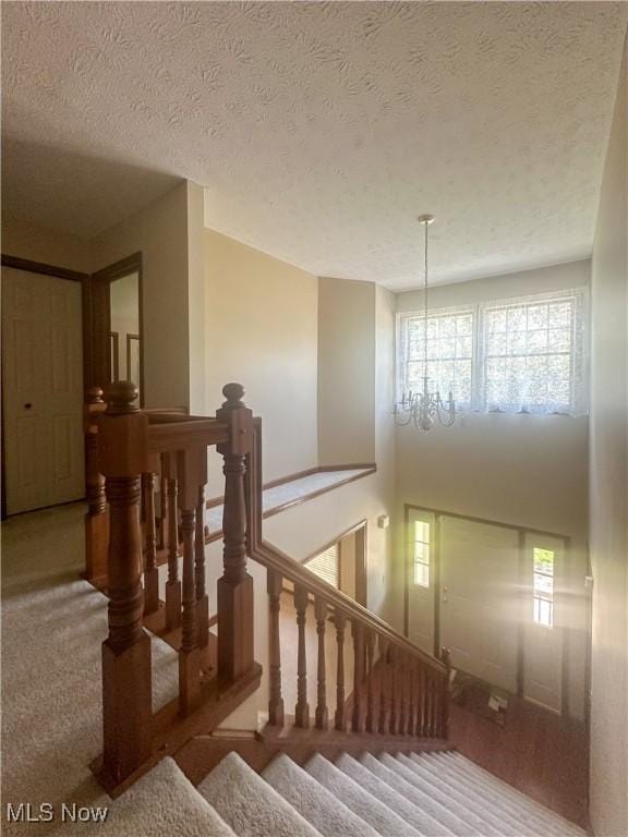 132 Beechwood Dr, Cortland, OH 44410 - stairs featuring plenty of natural light, carpet, a chandelier, and a textured ceiling