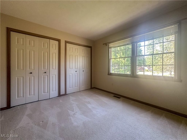 132 Beechwood Dr, Cortland, OH 44410 - unfurnished bedroom featuring light carpet and two closets