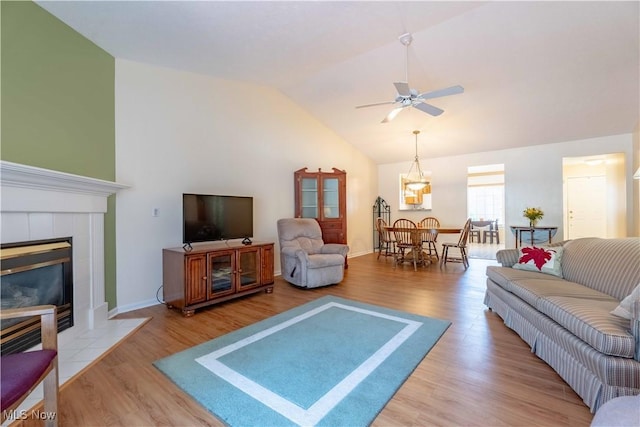 6706 Hogan Way NW, Canton, OH 44718 - living room with vaulted ceiling, ceiling fan, wood finished floors, a tile fireplace, and a chandelier