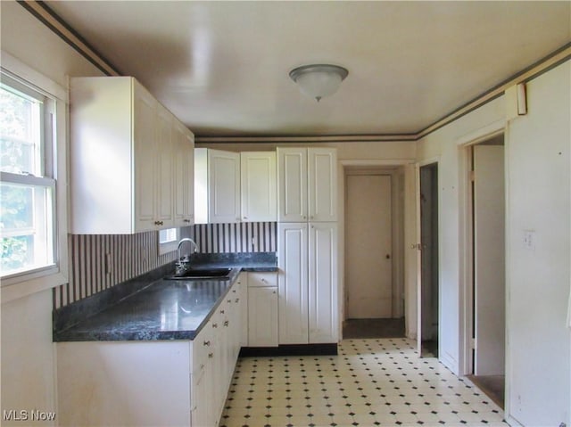 12316 Sunset Dr, Garfield Heights, OH 44125 - kitchen featuring healthy amount of natural light, dark countertops, white cabinets, and light floors