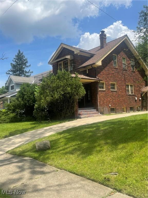 5257 Philip St, Maple Heights, OH 44137 - view of front facade with a front yard, a chimney, and brick siding