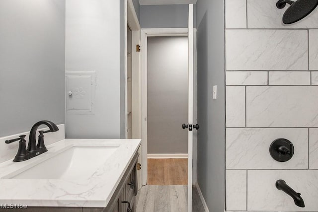 11202 Mountview Ave, Garfield Heights, OH 44125 - bathroom featuring tiled shower, wood finished floors, and vanity