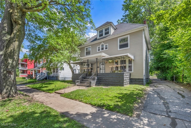 10602 Orville Ave, Cleveland, OH 44106 - american foursquare style home with a porch, a front yard, a chimney, and asphalt driveway
