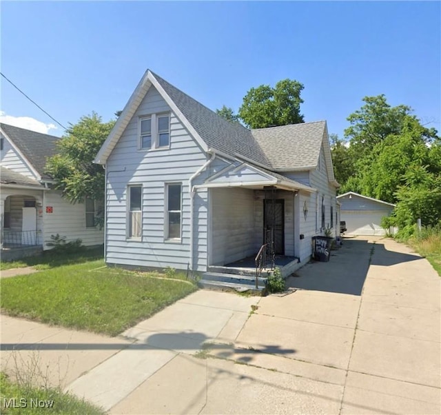 1532 Nebraska Ave, Toledo, OH 43607 - bungalow featuring an outbuilding, a garage, roof with shingles, and a front lawn