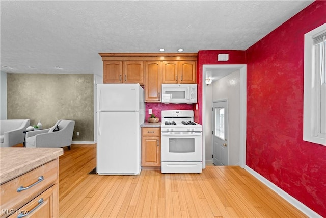 12610 Woodward Blvd, Garfield Heights, OH 44125 - kitchen with white appliances, light countertops, light wood finished floors, a textured ceiling, and brown cabinetry