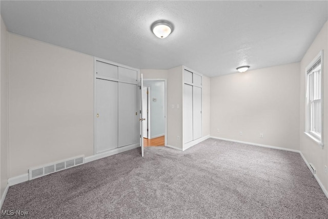 12610 Woodward Blvd, Garfield Heights, OH 44125 - unfurnished bedroom featuring carpet floors, multiple closets, and a textured ceiling