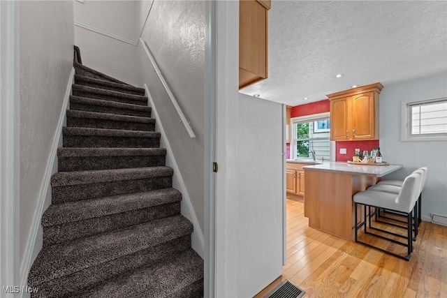 12610 Woodward Blvd, Garfield Heights, OH 44125 - stairway with hardwood / wood-style flooring, a textured ceiling, and recessed lighting