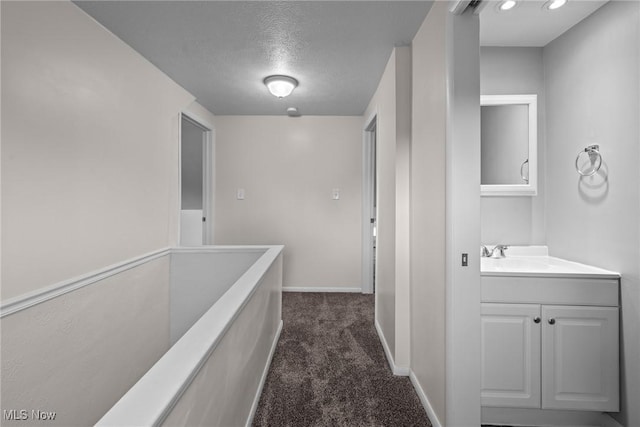 12610 Woodward Blvd, Garfield Heights, OH 44125 - hall with dark colored carpet and a textured ceiling