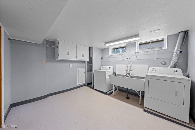 12610 Woodward Blvd, Garfield Heights, OH 44125 - laundry room featuring washing machine and clothes dryer, cabinet space, light flooring, and a textured ceiling