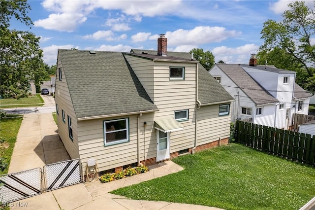 12610 Woodward Blvd, Garfield Heights, OH 44125 - back of house with a shingled roof, a chimney, and a gate